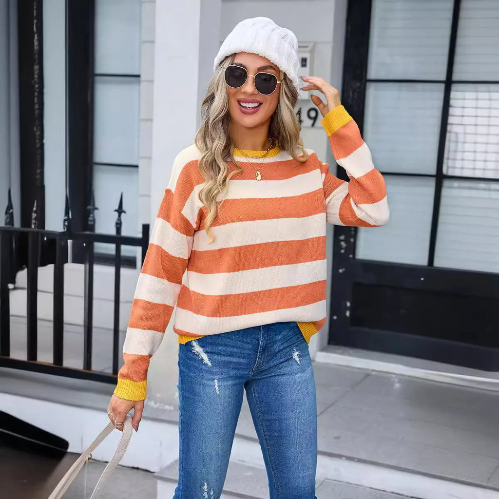 Women's loose blue acrylic sweater with long sleeves and a striped pattern on a hanger.