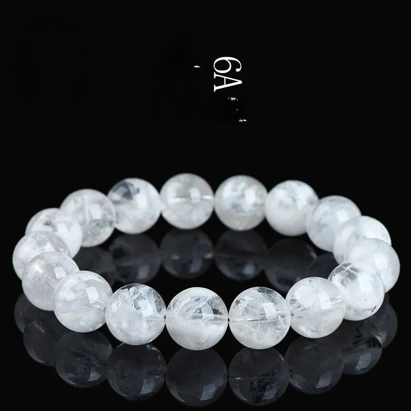 Women's natural blizzard snowflake round bead crystal bracelet with geometric design on a wrist.
