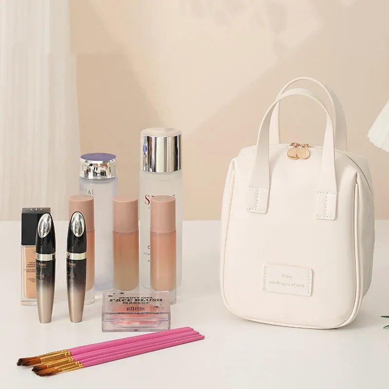 Shell-shaped handle-top cosmetic bag in cream white, PU material, 20x16x8 cm, for travel make-up storage