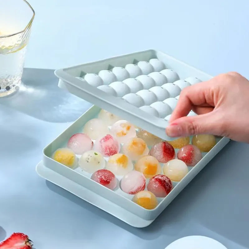 Blue 33-grid round silicone ice cube tray with transparent lid next to pink version, showing dimensions.