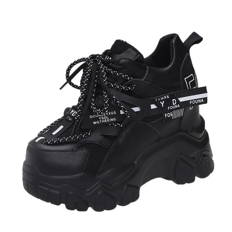 White women's low-top platform sports trainers with mesh panels and a black cross-strap on a rubber sole.