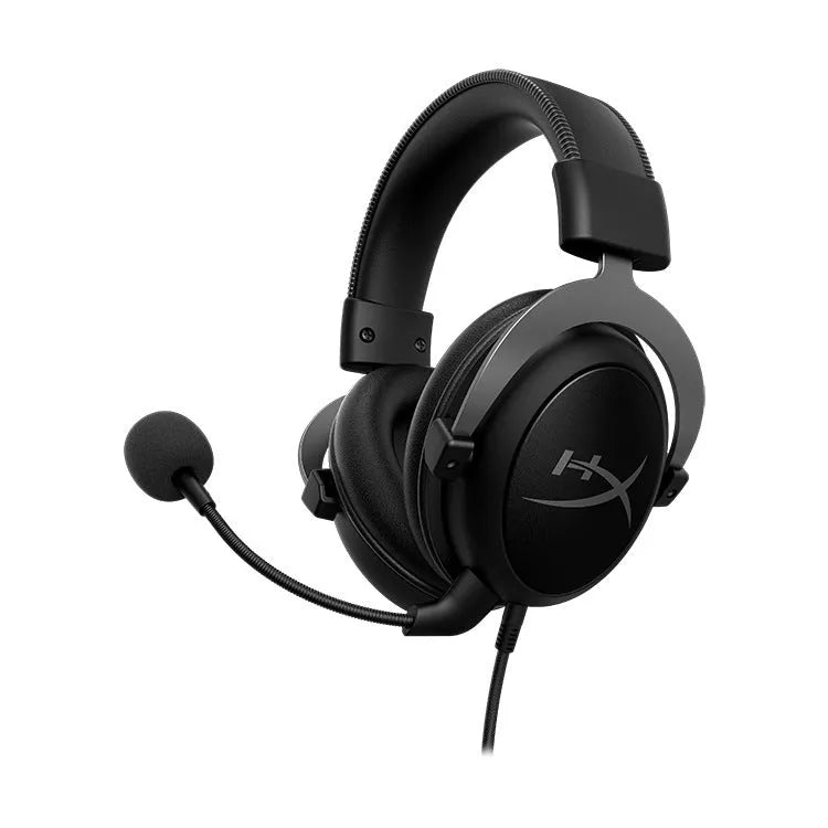Black red wired gaming headset with detachable microphone on a desk next to a USB sound card remote control.