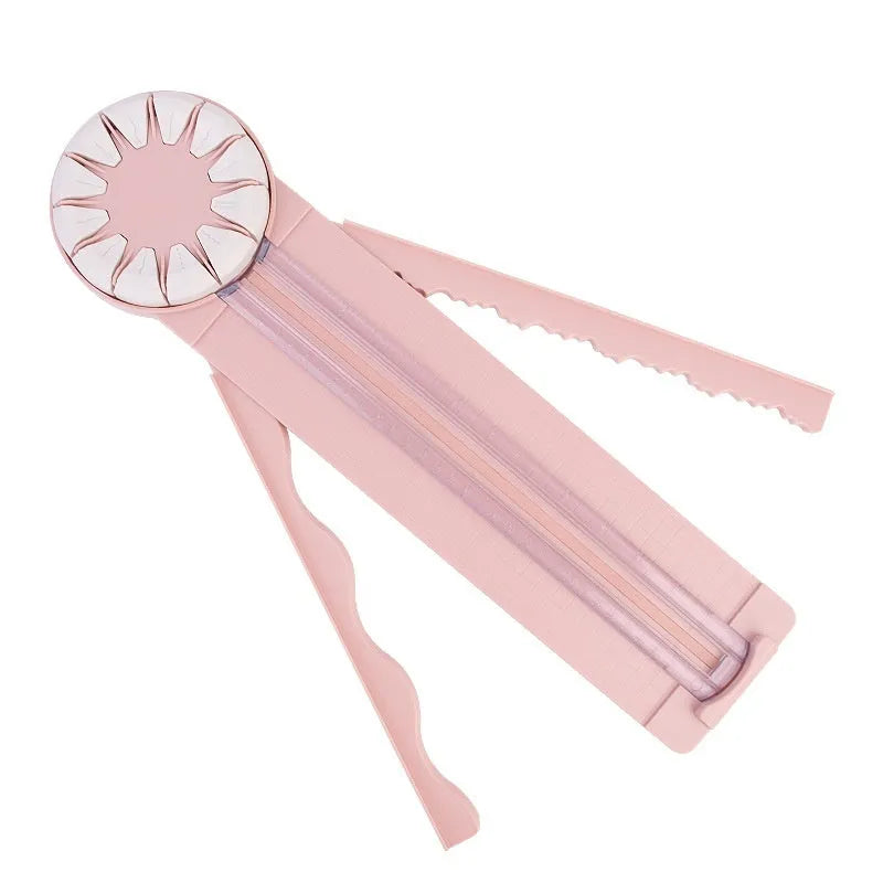 A pink plastic 12-in-1 multifunctional paper cutter with a dotted design on a flat surface.