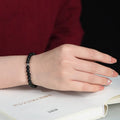 Natural black obsidian bracelet with S925 sterling silver flower charm and dragon phoenix decorations on wrist
