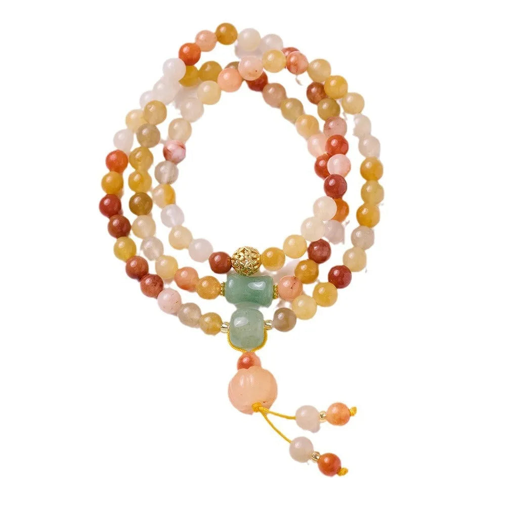 Women's handcrafted Jinsi Jade bracelet with pumpkin-shaped beads and tassels on a wrist.