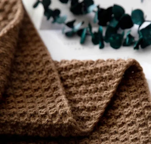 Nordic fringed knit ball throw blanket in 130x170cm size on a sofa