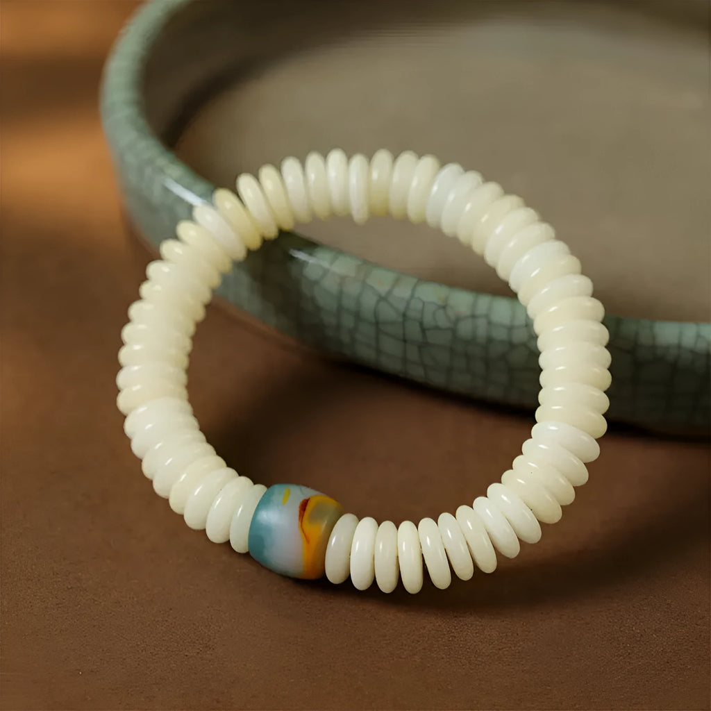 Close-up of a White Bodhi seed bracelet or handheld strand showing 3x10mm natural beads.