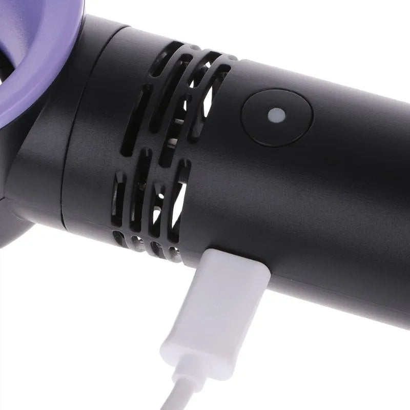 A compact portable bladeless fan with USB cable on a desk.