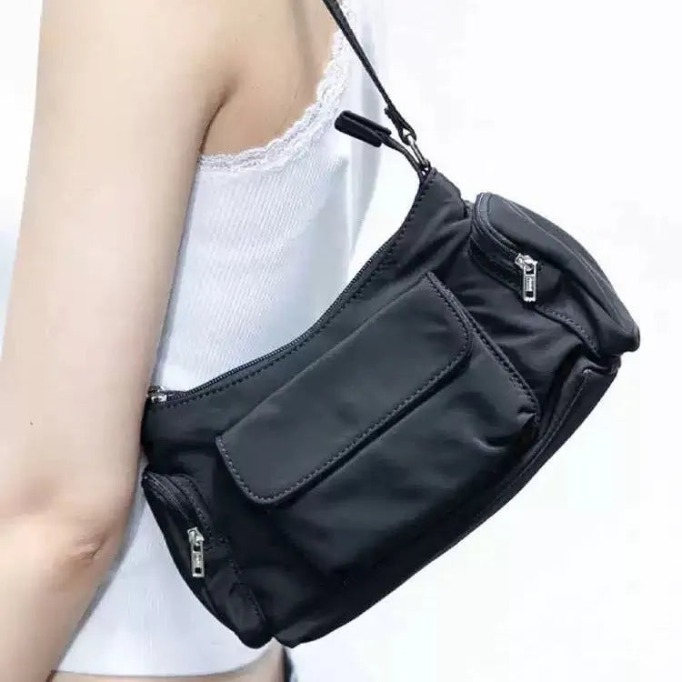 Simple black lightweight nylon shoulder bag with double pockets showing side line detailing