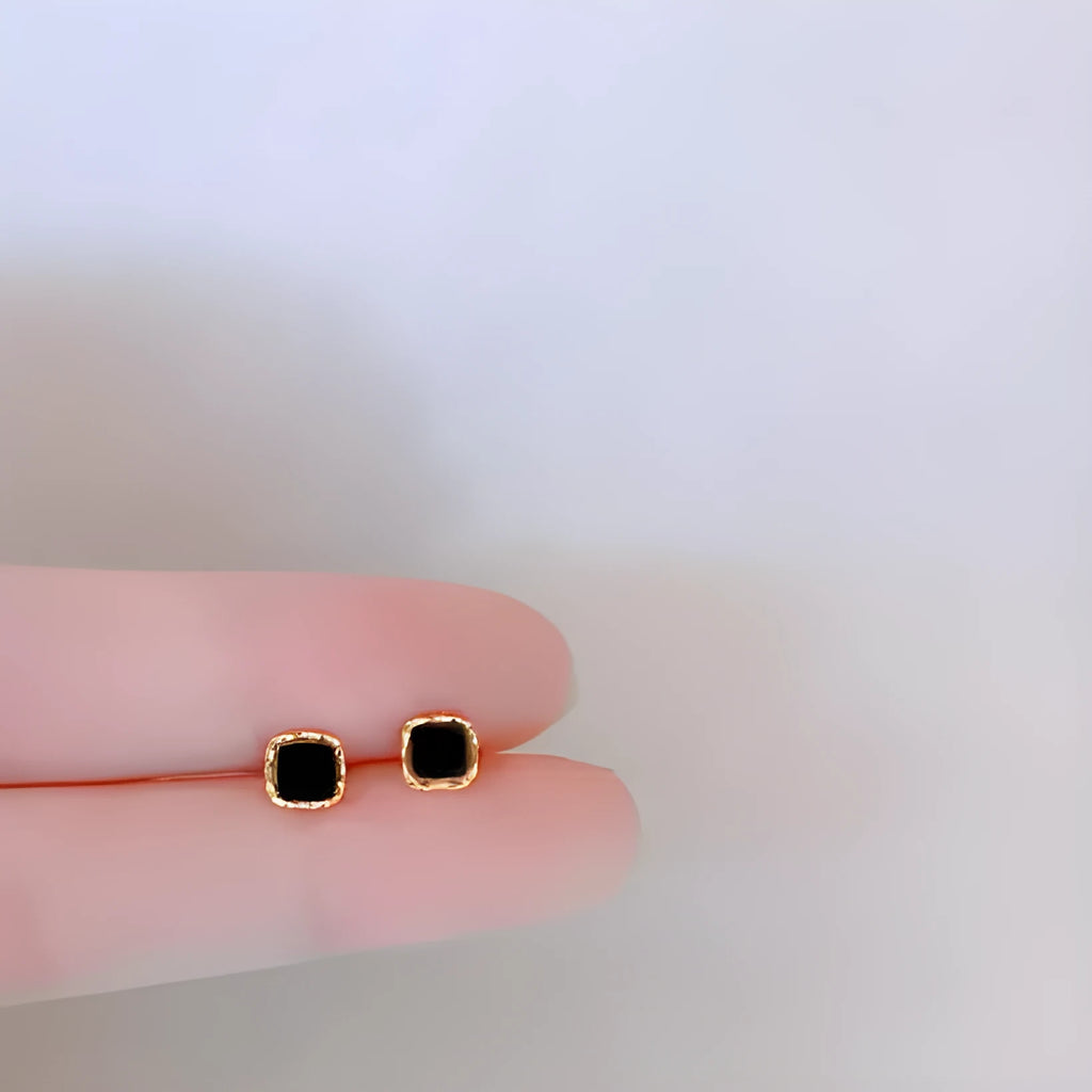 Black round mini ear studs with inlaid zircon, silver plated alloy, 10mm diameter, on a plain background