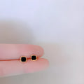 Black round mini ear studs with inlaid zircon, silver plated alloy, 10mm diameter, on a plain background