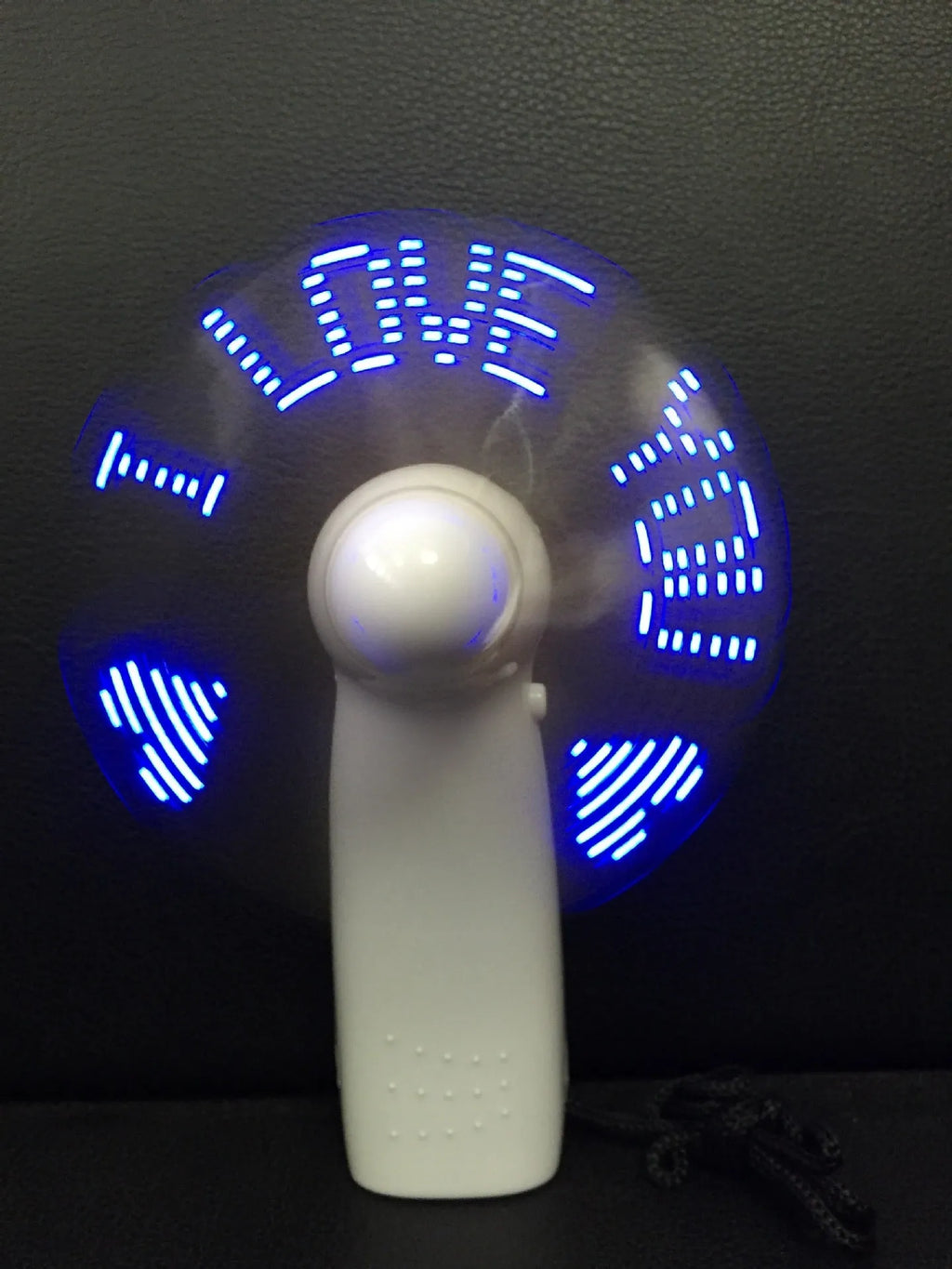 White mini handheld fan showing blue and red LED lights forming 'I Love You' message on its front.