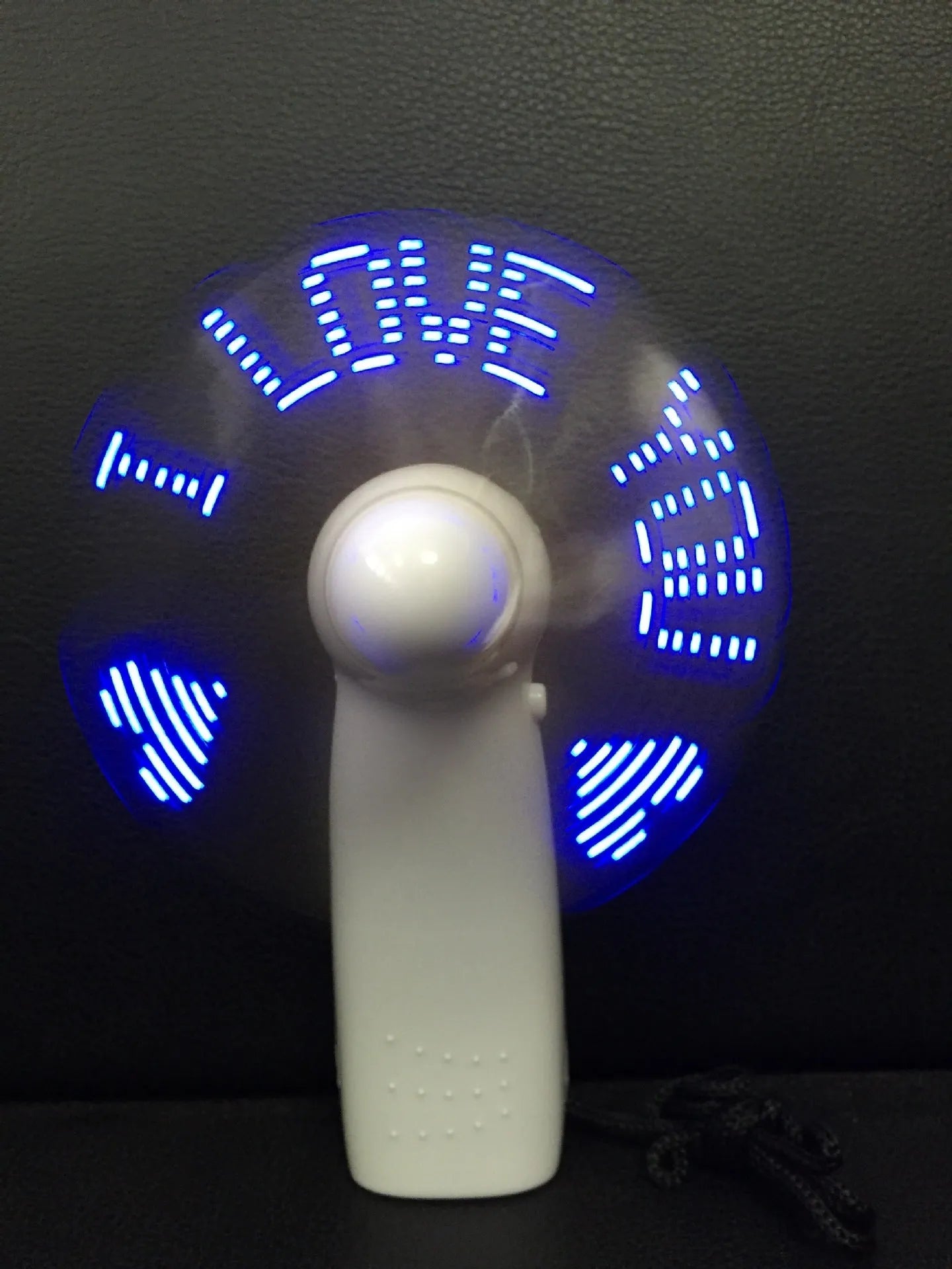 White mini handheld fan showing blue and red LED lights forming 'I Love You' message on its front.