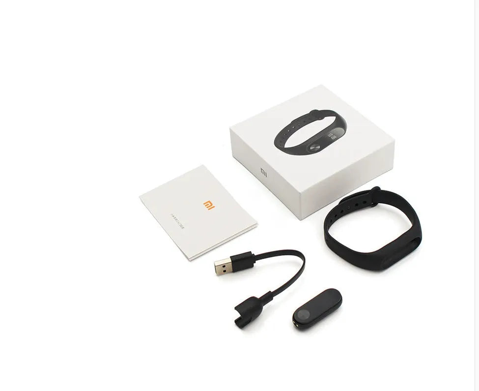 Xiaomi Mi Band 2 black fitness tracker on wrist showing OLED display with heart rate reading.