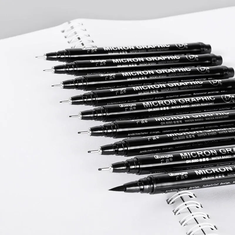 Set of black comic drawing pens with multiple nib sizes in a storage bag organiser.
