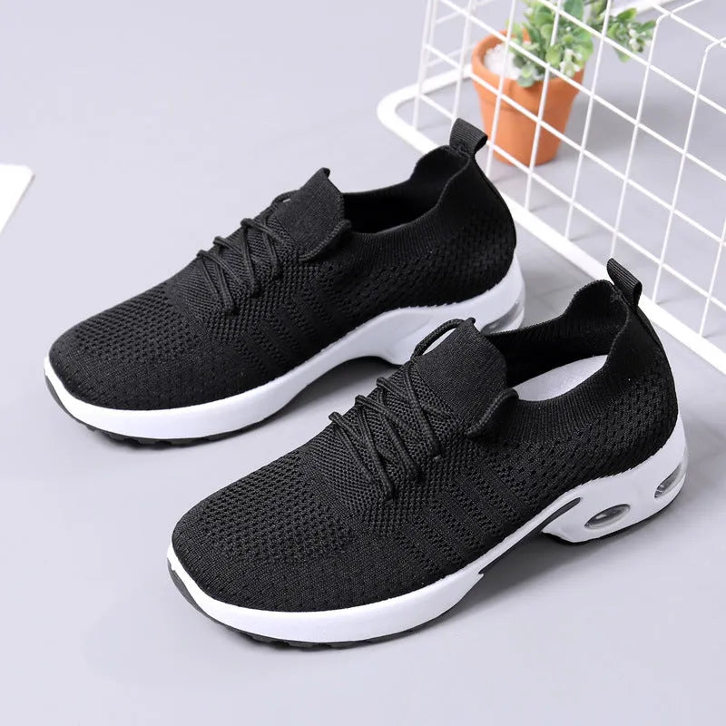 Women's black lace-up casual sneakers with a mesh upper and a textured non-slip PVC sole.