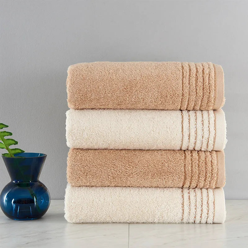 Set of three cotton towels in beige and brown including large bath towel, hand towel, and small washcloth