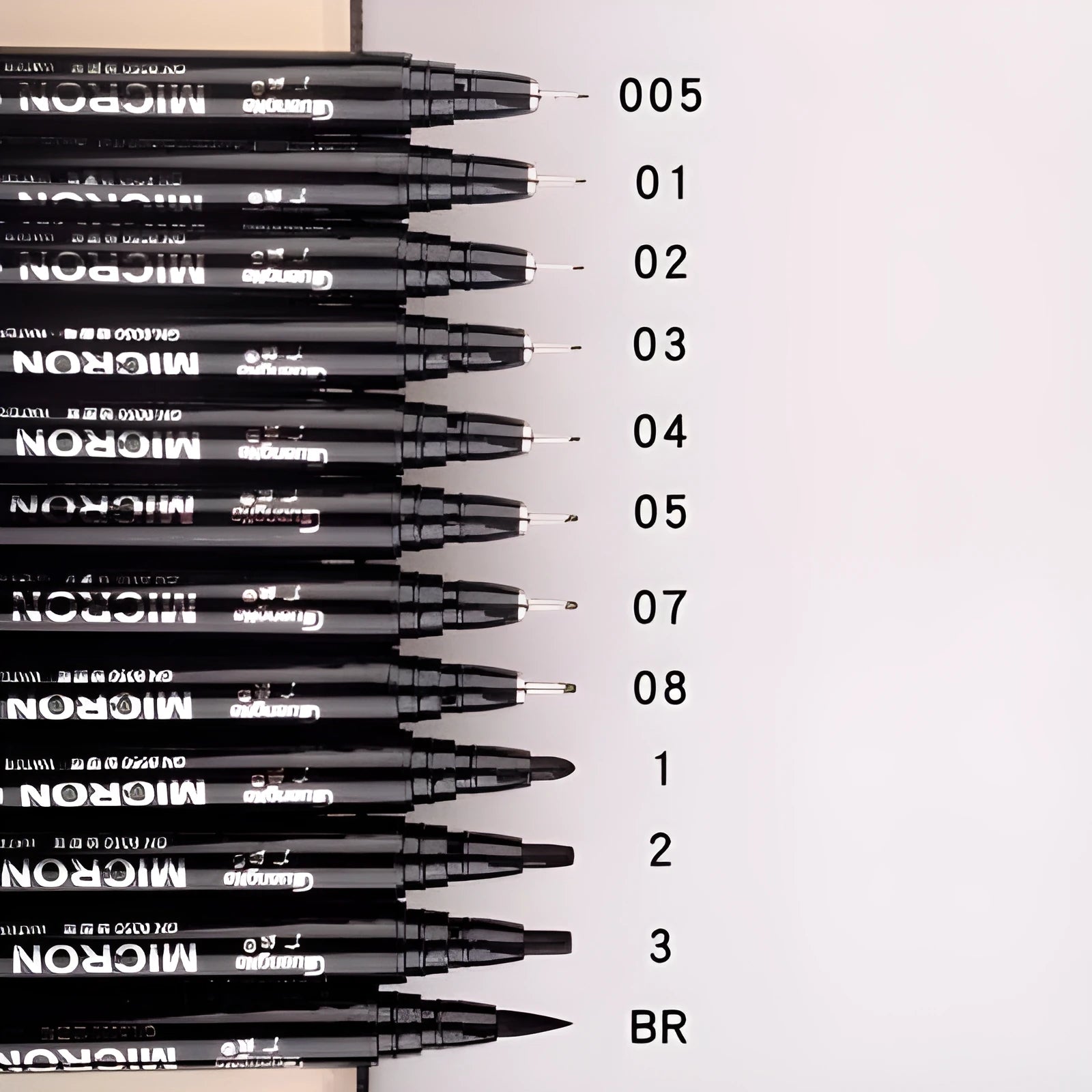 Set of black comic drawing pens with multiple nib sizes in a storage bag organiser.