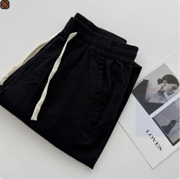 Man wearing beige loose-fit straight leg casual trousers with a drawstring waistband.