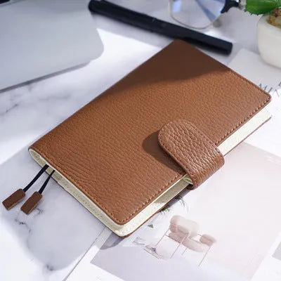 A6 leather notebook with lychee pattern cowhide cover showing loose-leaf binding in three colour options