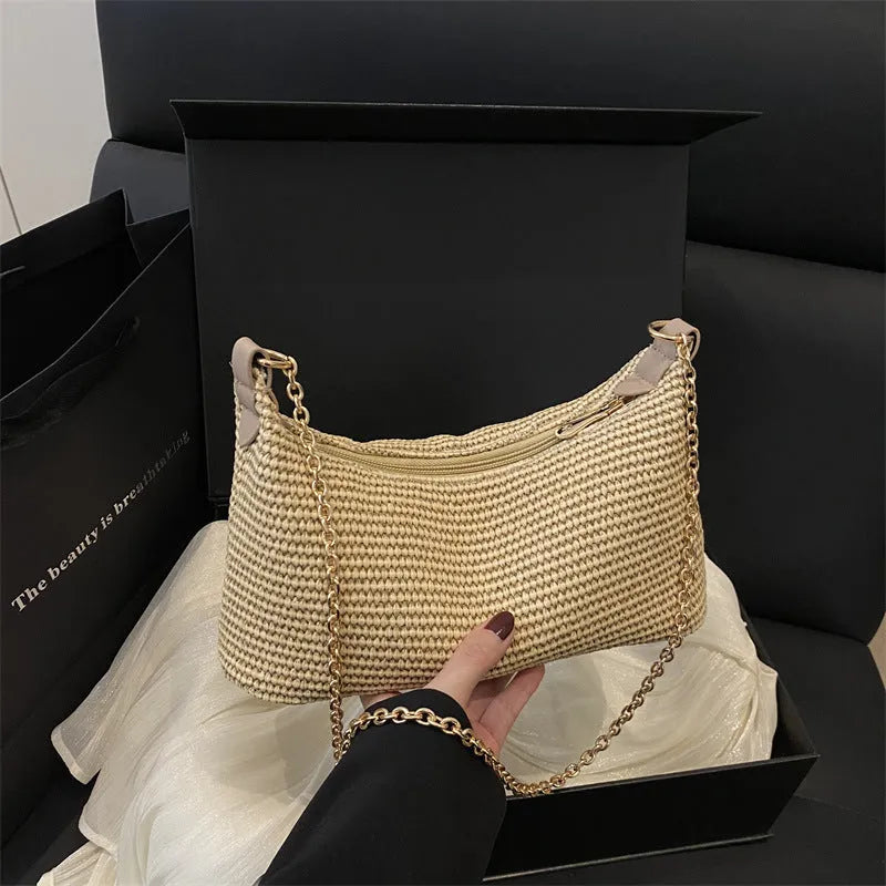 Woven straw beach shoulder tote bag in khaki colour with visible stitching and an outer pocket.