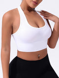 Black women's cross-back sports bra with moulded cups on a hanger