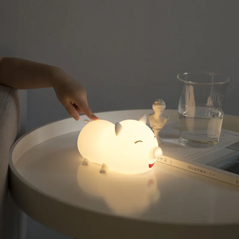 Dudu pig cartoon night light with silicone lampshade and warm yellow LED glow on a bedside table