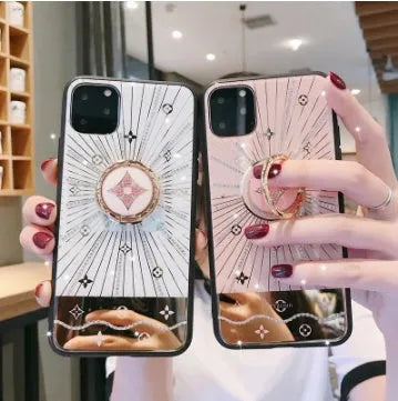 Rose gold and white diamond ring phone stands attached to iPhones, showing grip and kickstand functions.