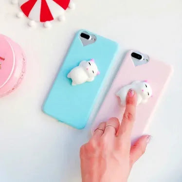 Soft pink silicone iPhone case with a raised 3D cartoon cat design, shown fitted on a phone.