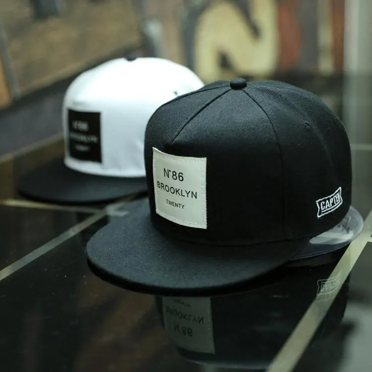 Adjustable unisex baseball cap in cotton polyester with short brim, available in black or white