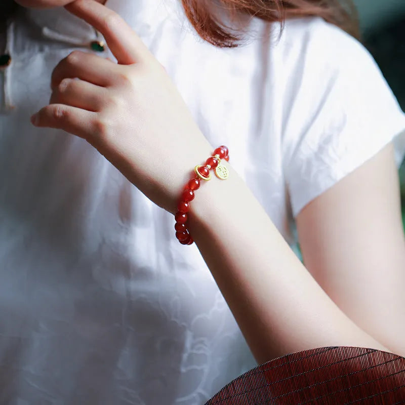 Natural red agate bracelet with woven design and blessing card, shown in 10mm bead size.