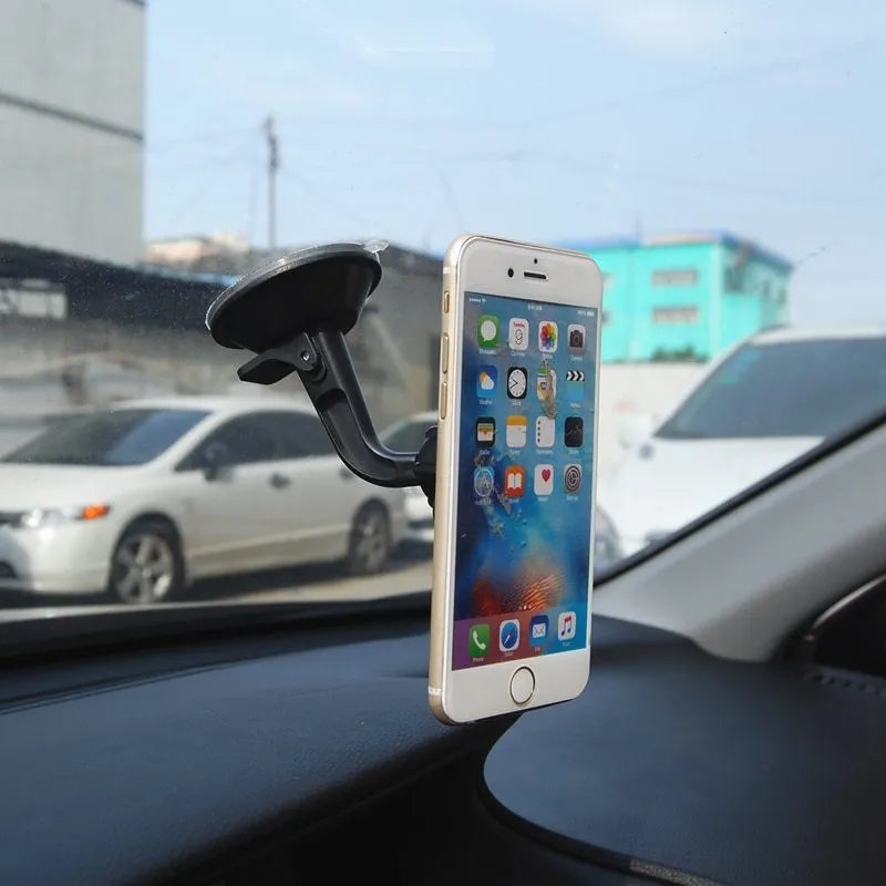 Classic black magnetic car phone holder mounted on a car dashboard, showing 360-degree rotation.