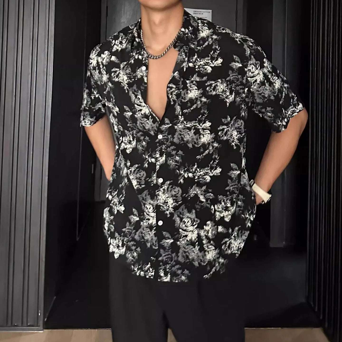 Man's loose black short sleeve shirt with a white floral print pattern.