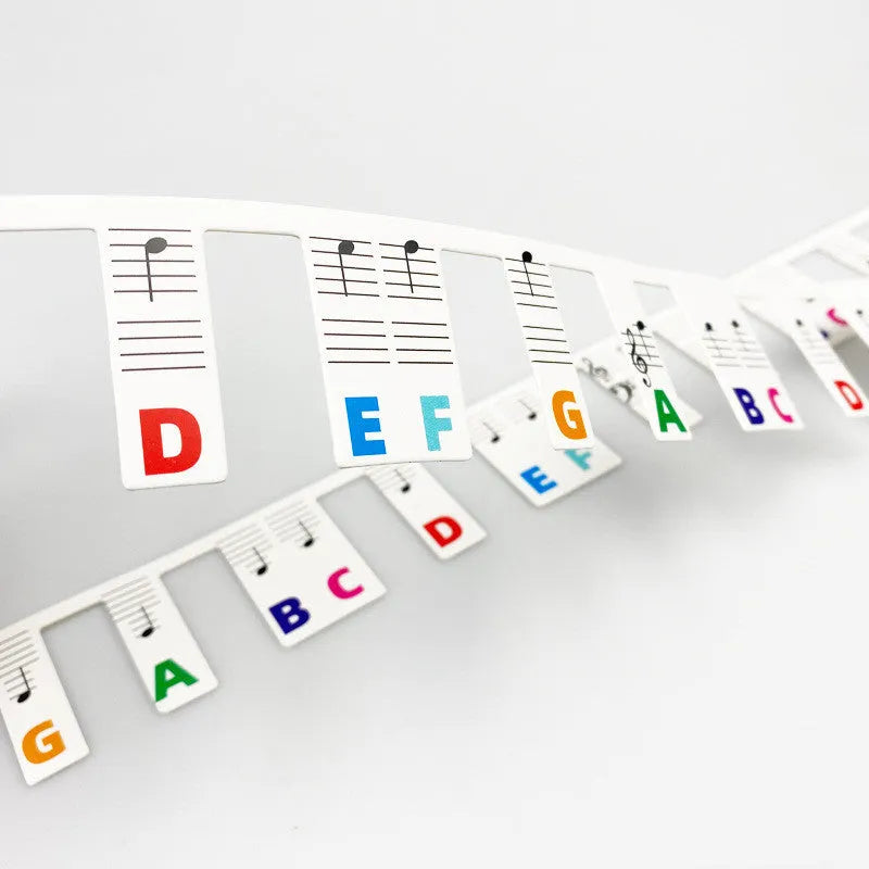 White cardboard piano keyboard stickers showing staff notation for 88 keys, with black notes and colour note bar options