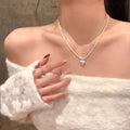 Double-layer brushed silver heart pendant necklace on a model, showing adjustable chain length.