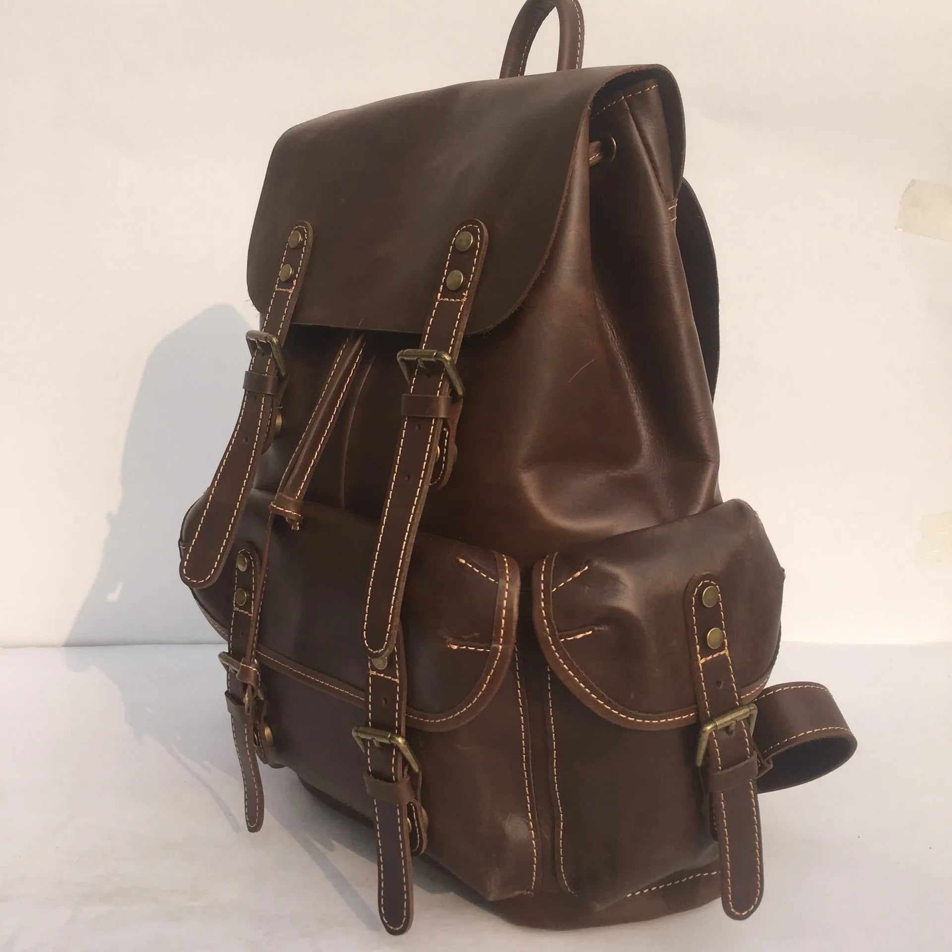 Brown men's leather backpack made from top-layer cowhide with an air pillow belt back system.