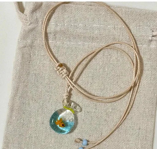 Women's coloured glaze pendant necklace on a braided cotton and linen clavicle chain, showing artisan finish.