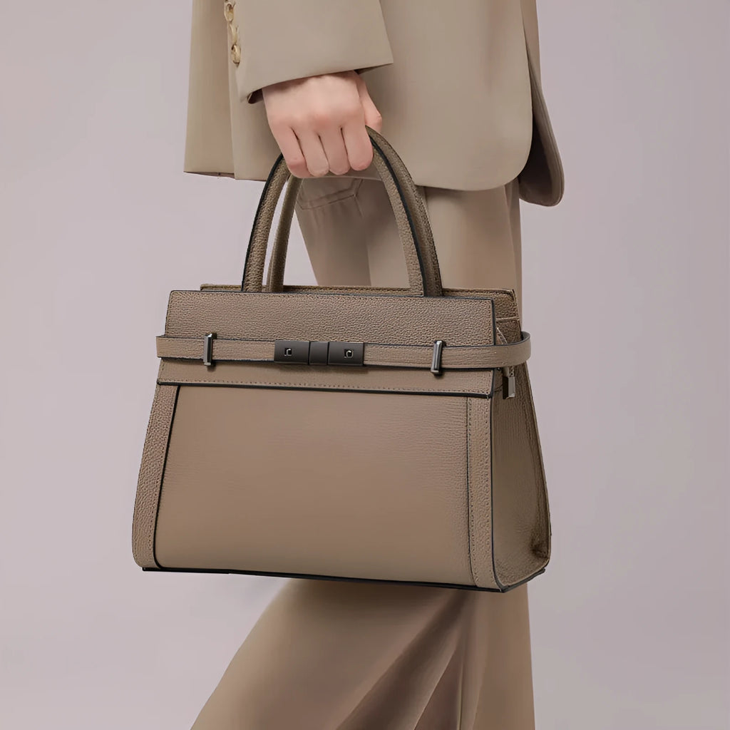Women's black genuine leather crossbody clamshell handbag with multiple internal zip pockets.