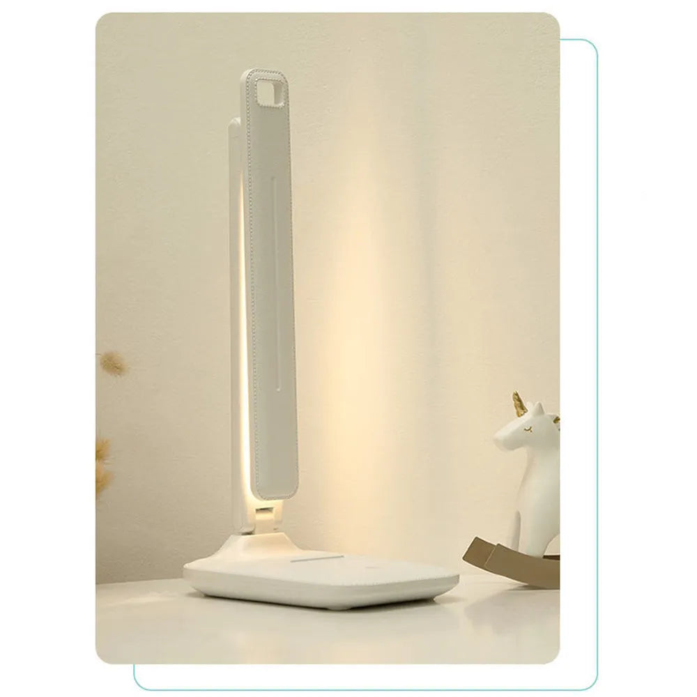 White USB rechargeable bedside lamp with touch dimming controls on a table.