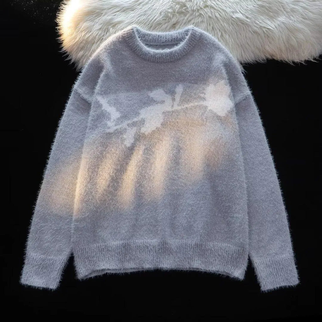 Man wearing a dark grey pullover sweater with a large rose-coloured flocking horse print on the chest.