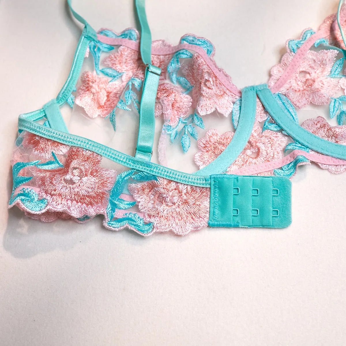 Pink women's mesh pettiskirt suit with embroidery detail, shown as a complete bikini set.