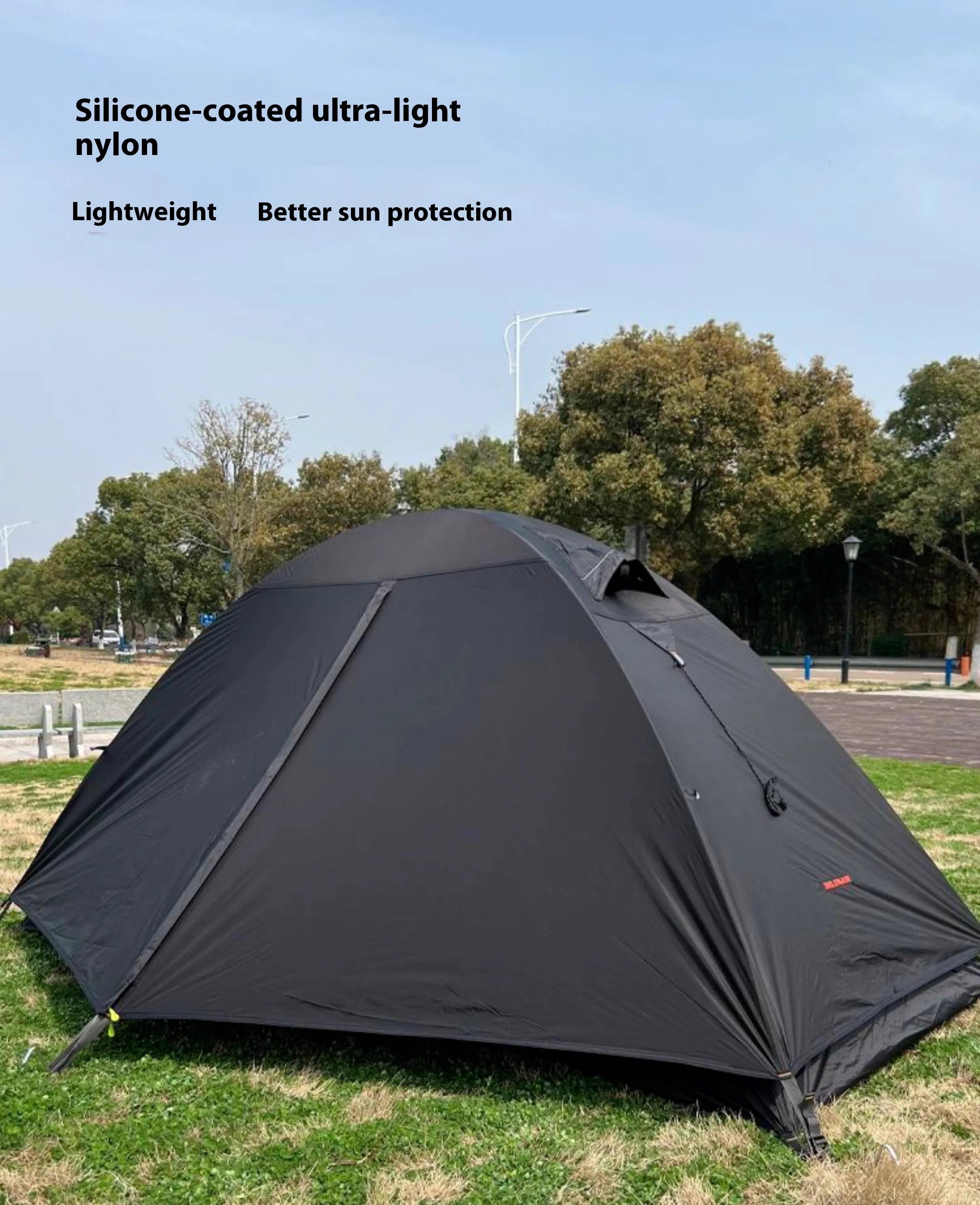 Red single-person backpacking tent with aluminium poles pitched in a forest, showing double-skin design and mesh panel.