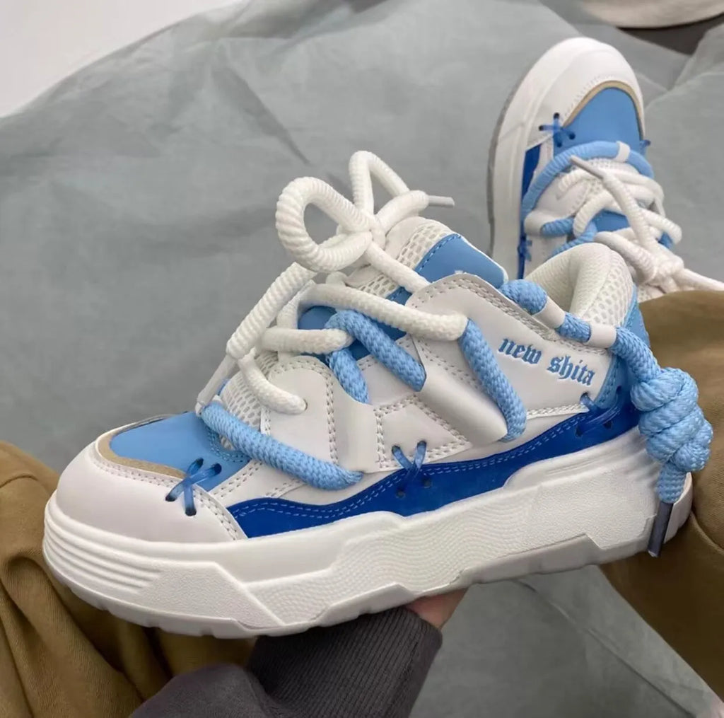 Women's grey clunky platform sneakers with a thick rubber sole and lace-up front, shown on a white background.