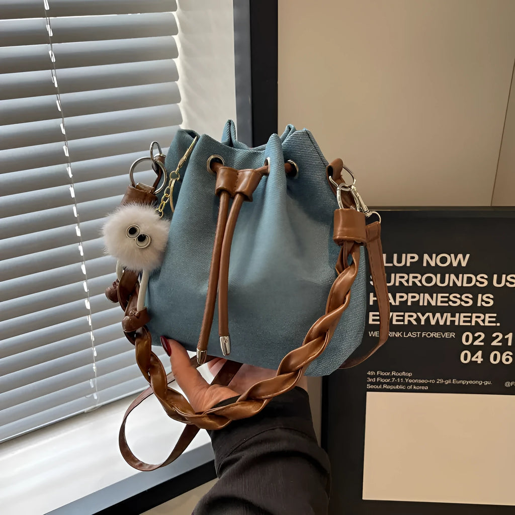 Blue synthetic leather cross-body bucket bag with adjustable strap and outer pocket