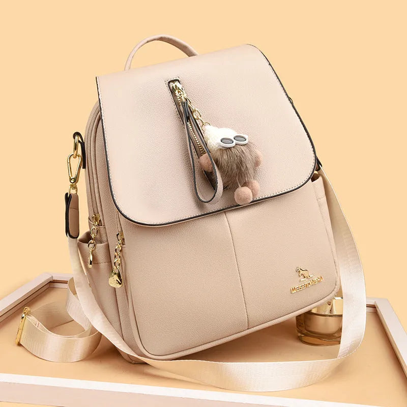 Genuine leather travel backpack with pendant in beige colour for female students, featuring belt decoration and splicing details