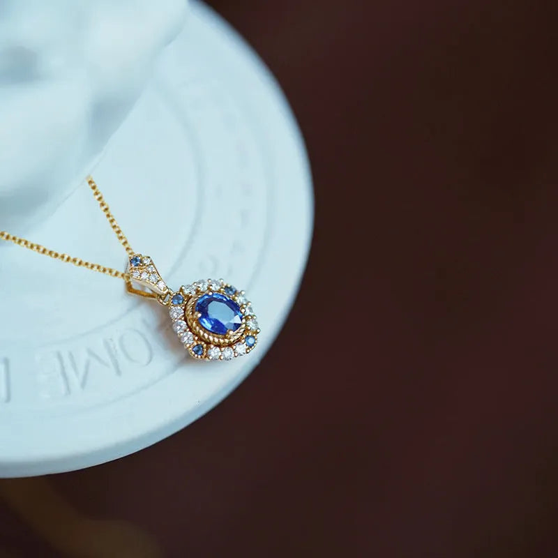 Yellow gold-colour adjustable box chain necklace with a mixed gemstone inlaid pendant on a white background.
