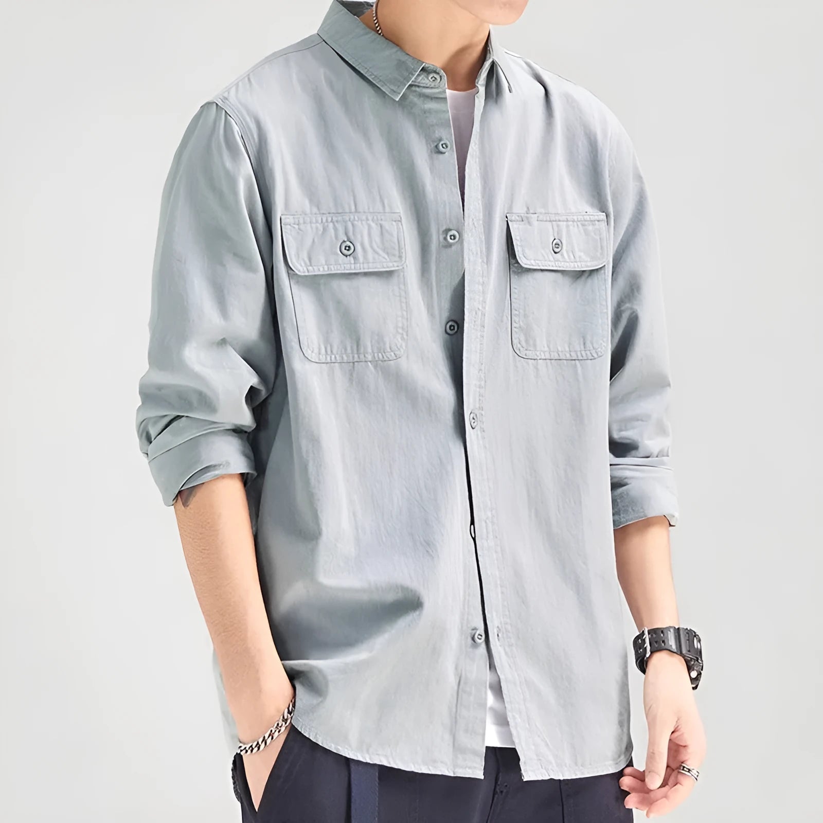 Man wearing a loose-fit light grey long sleeve cardigan-style shirt made from polyester.