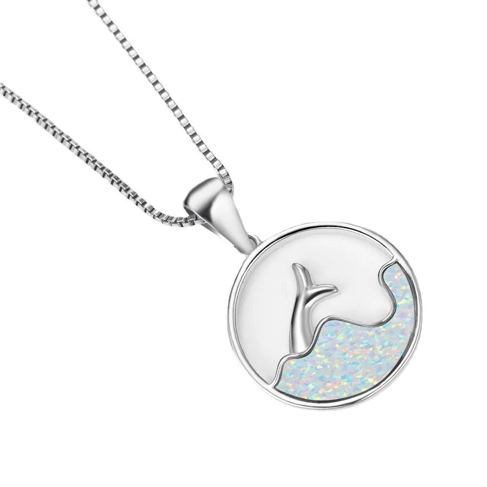 Close-up of a geometric pendant fishtail necklace with a round blue opal stone and white gold electroplated finish.