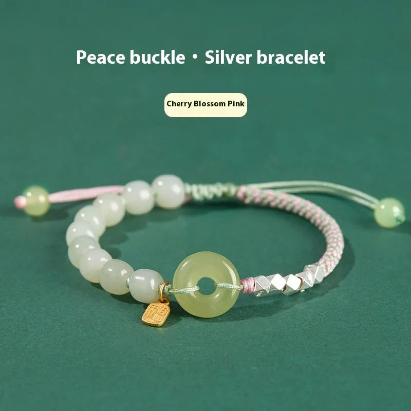 Woven bracelet with a natural Hetian jade flower charm and safety buckle in maple leaf yellow.