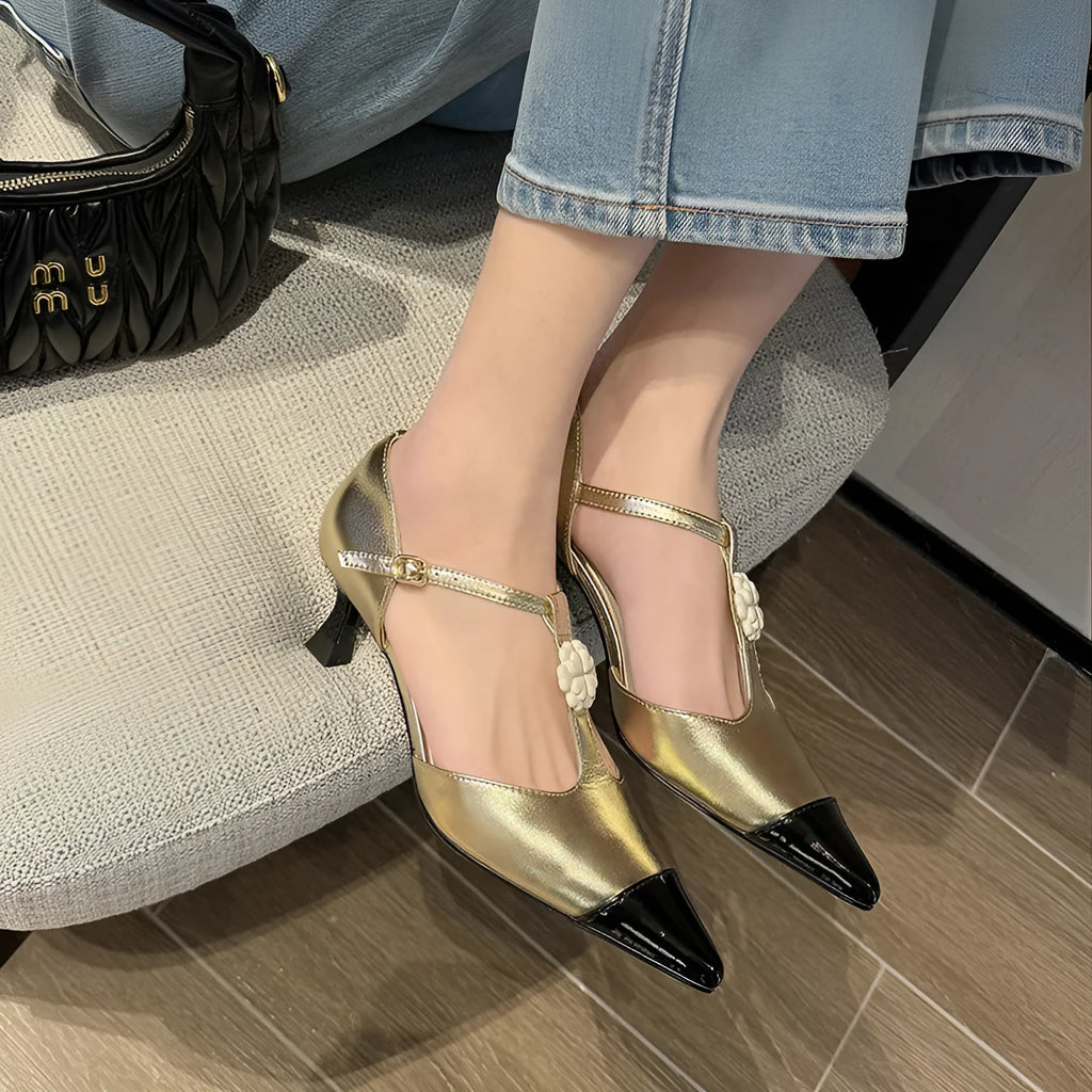 Women's black stiletto heel sandals with pointed toe, flower buckle, and shallow mouth opening.